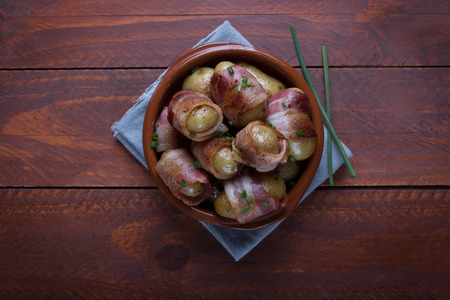 Grilled baby potato wrapped in bacon on the wooden backgroundの写真素材