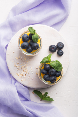 Glass of yogurt with blueberries and mango mousse, chia seed and oat granolaの写真素材