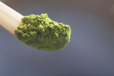 Top view of green tea matcha in a spoon on dark surface.の写真素材