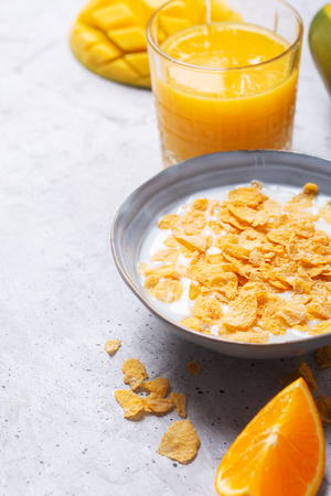 Breakfast which consist of different yellow ingredients - sereales and fruits. Gray backgroundの写真素材