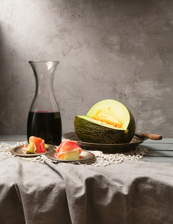 Still life with fresh melon, jamon and red wine on the table. Photo in the style of paintings of the Holland of the 17th centuryの写真素材