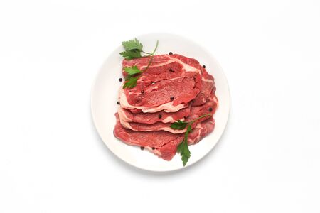fresh raw beef steak on the plate isolated on white background, top viewの写真素材
