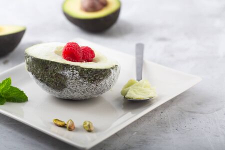Homemade organic avocado and pistacho ice cream with raspberriesの写真素材