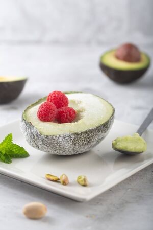 Homemade organic avocado and pistacho ice cream with raspberriesの写真素材