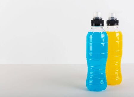 Isotonic energy drink. Bottles with blue and yellow transparent liquid, sport beverage on a whiteの写真素材