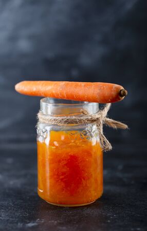 Carrot Jam with orange juice on a black background, vertical orientationの写真素材