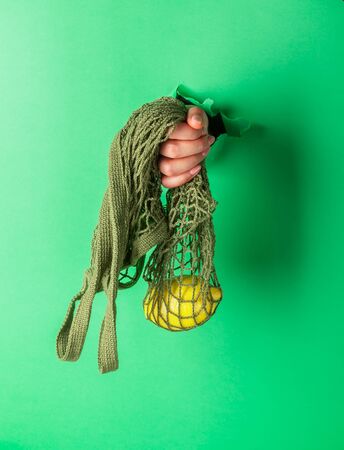 A woman holds reusable Cotton String Portable Shopping Handbag with bananasの写真素材
