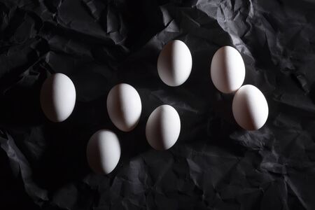 Getting ready for Easter. Seven white eggs on a dark background for coloring. We paint eggs with the...