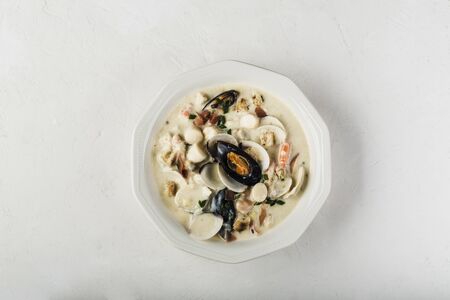 Clam chowder in a white plate.