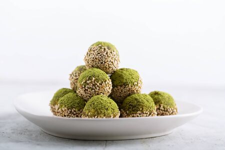 Modern no bake green chai matcha energy bites prepared with nuts, cocoa, chocolate, oats, sesame....