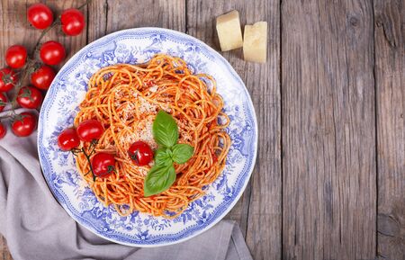 Pasta with tomato sauce and cherry tomatoes with parmesan on a wooden rusticの写真素材