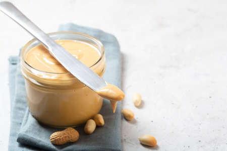 Peanut butter in a glass jar on the table with copy space