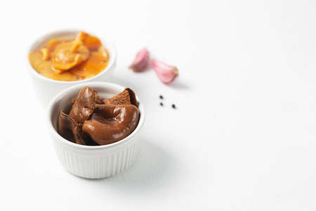 Ceramic bowls with canned mushrooms. Fermented food on a white background with copy space