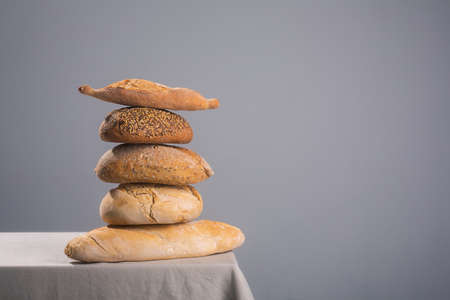 Pile of bread on a table covered with a tablecloth