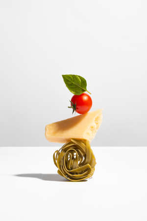 Creative still life with balancing food on white background