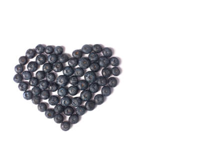 Blueberries laid out in the form of a heart isolated on a white background. Copy space