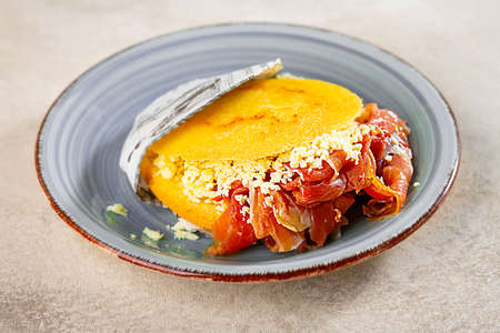Stuffed arepa on a plate prepared from cornmeal, traditional cuisine of Colombia and Venezuela