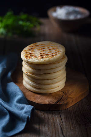 Arepa is a type of meal made from ground corn dough, cornmeal, traditional Colombian food, dark and moody styleの写真素材