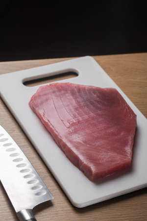 Raw tuna fillet on a kithchen cutting boardの写真素材