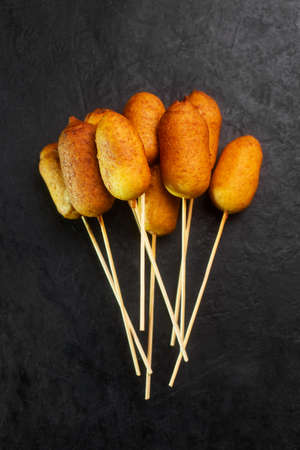 Corn dog cooked with sausage and wheat dough with the addition of corn flour, black background top viewの写真素材