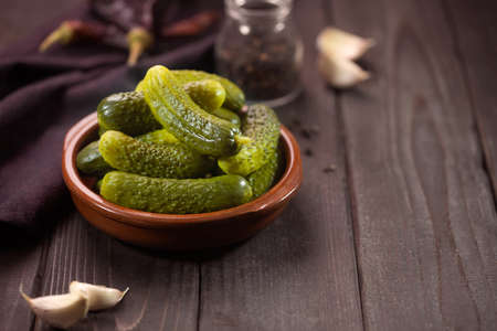 Pickled gherkins. Salted Cucumbers on a dark background with copy spaceの写真素材