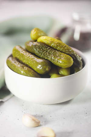 Pickled gherkins. Salted Cucumbers on a white concrete backgroundの写真素材