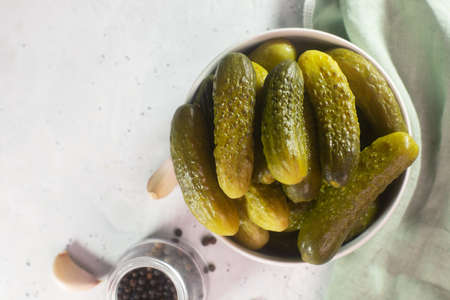 Pickled gherkins. Salted Cucumbers on a white concrete background, top view flat layの写真素材