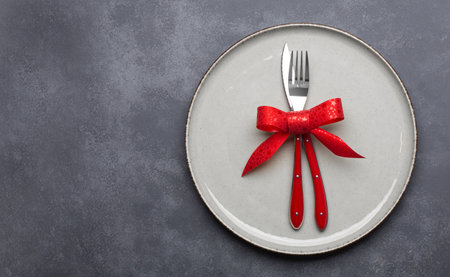Christmas table setting consisting of a plate and cutlery. Top view with copy spaceの写真素材
