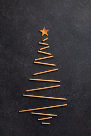 Creative Christmas tree made from paper straws for cocktails on dark backgroundの写真素材