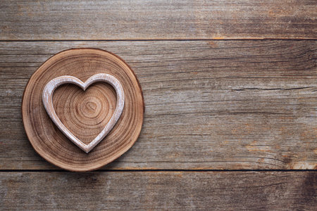 Wooden heart on a brown wooden background. Simple concept for Valentines day holidayの写真素材