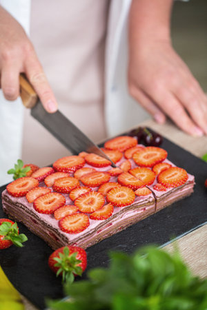Cut of no baked raw cheesecake made with dates, cashews and strawberries. High quality photoの写真素材