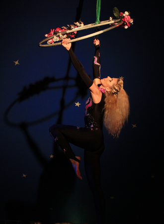 Young blonde woman gymnast show act on the aerial ring at the circusの写真素材
