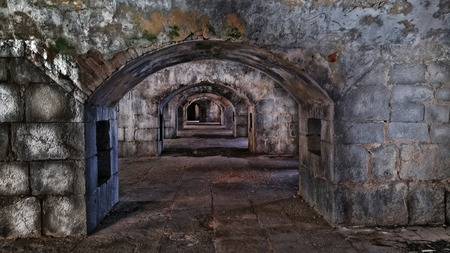 dark casemates inside the old fort. Archs made of stone stretch deep into the fortressの写真素材