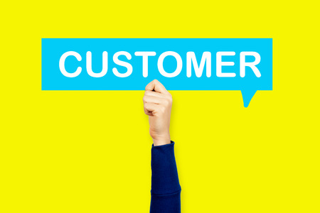 Hand holding the word customer on speech bubbleの写真素材