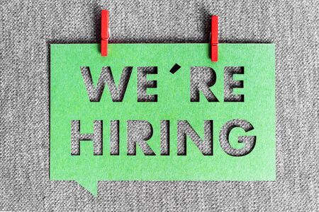 "We're hiring" green banner on grey texture background. Job vacant and employment concept.の写真素材