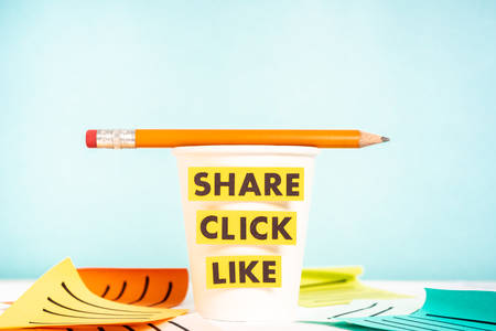 Paper cup with a pecil and the words share, click and like. Concept of digital marketing, analysis,...