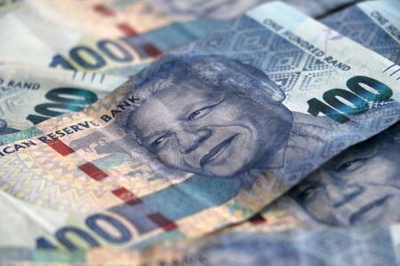 Nelson Mandelas face on the South African 100 rand bill pile of money currencyの写真素材