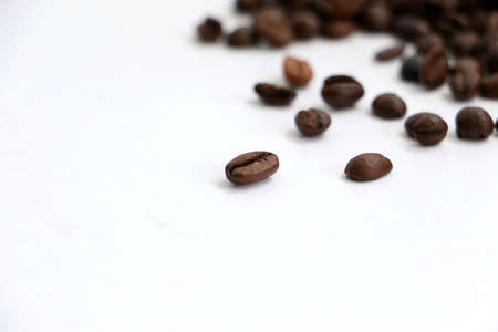 Isolated pile of coffee beans on a white background with space for textの写真素材