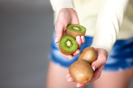 Beautiful young girl holding kiwi. Healthy food. vegetarianismの写真素材