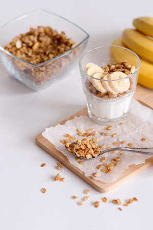 Ingredients for homemade oatmeal granola in glass jar. Oat flakes, honey, raisins and nuts. Healthy breakfast concept with copyの写真素材