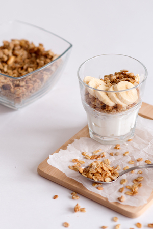 Ingredients for homemade oatmeal granola in glass jar. Oat flakes, honey, raisins and nuts. Healthy breakfast concept with copyの写真素材