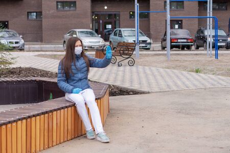 Covid concept 19. portrait of a Caucasian woman on the street and showing a stop gesture with her hand, the woman puts on a protective mask and gloves to prevent the rapid spread of the corona virusの写真素材