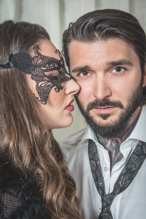 Young woman portrait with a lace mask teasing an elegant man as in the movie Fifty Shades Darkerの写真素材