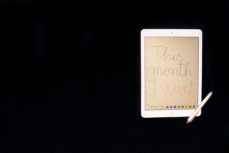 This month I want handwriting on tablet with stylus touch pen on black backgroundの写真素材
