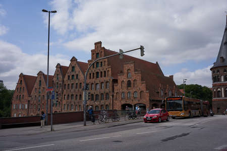 Luebeck, Germany - July 20, 2021 - Six red-brick buildings, the Salzspeicher along the Trave waterfront near the Holstentorのeditorial素材