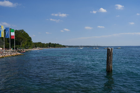 The clear blue water of Lake Garda with wooden stake on a summer afternoonの写真素材