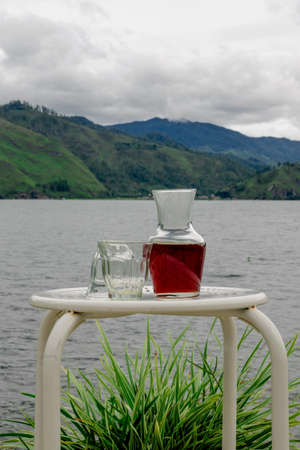 glass of red wine on the table on the lake mountainの写真素材
