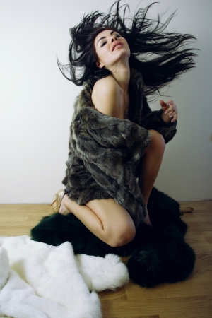 young girl with several natural fur coatsの写真素材