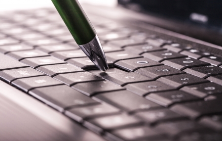 Using a laptop, pencil on laptop keyboard