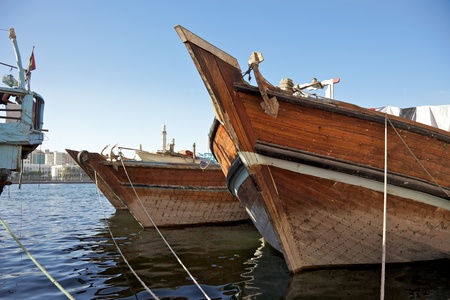 The bows of traditional wooden trading dhows moored in Dubai Creek, UAE.